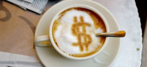 Coffee cup with a dollar symbol drawn in the foam